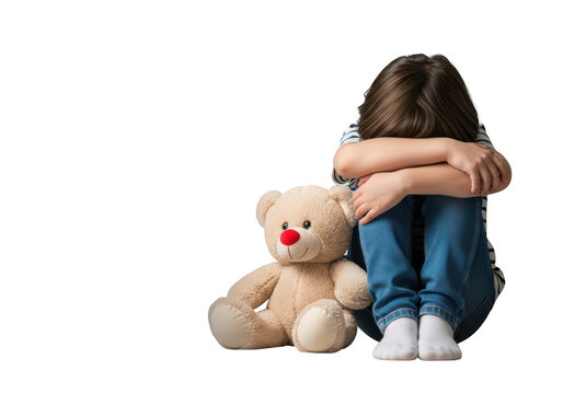 A really upset and depressed sad child sitting on the floor with head down with a light pink teddy bear isolated on transparent background