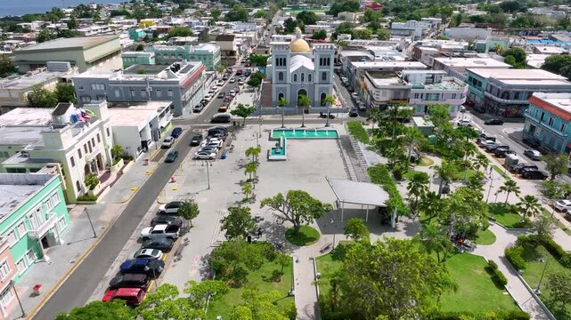 Drone footage passing over the town square and Parroquia San Antonio de Padua with the Atlantic ocean in the background, Isabella, Puerto Rico