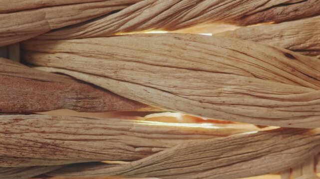 Close-up of woven water hyacinth fibers. The camera captures the intricate depth and shadows of the braided material