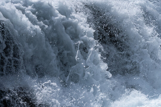 Turbulent river water with foam and spray nature backdrop