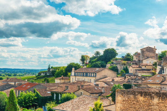 Historic hillside buildings overlooking vineyards of Saint Emilion village in famous French wine region, Bordeaux, France. Wine tourism, medieval town in Nouvelle-Aquitaine