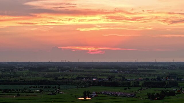 time-lapse，Aerial sunset panoramic view of vast rural farmland and village under golden twilight sky