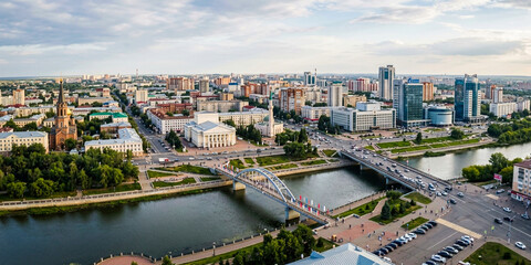 Obraz premium Picturesque cityscape featuring a curved bridge over a river, a cathedral, and classic European buildings