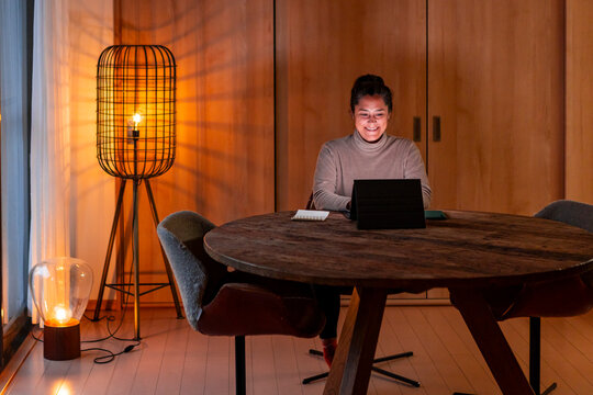 Woman working from home using a tablet at night