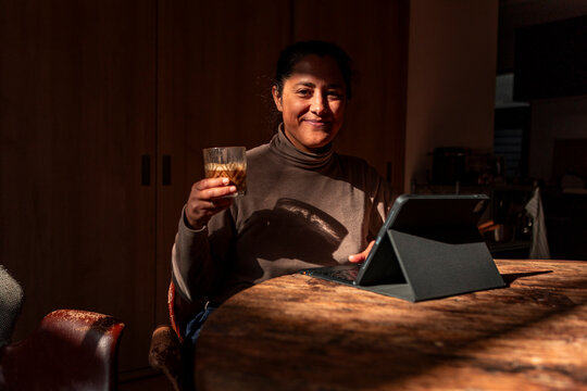 Woman working from home with tablet and drink