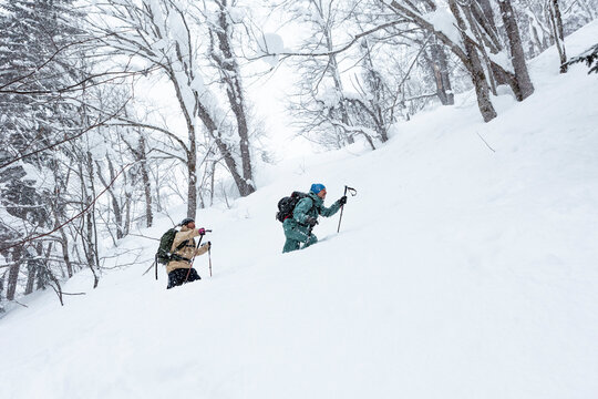 Backcountry skier climbing through deep powder in Hokkaido