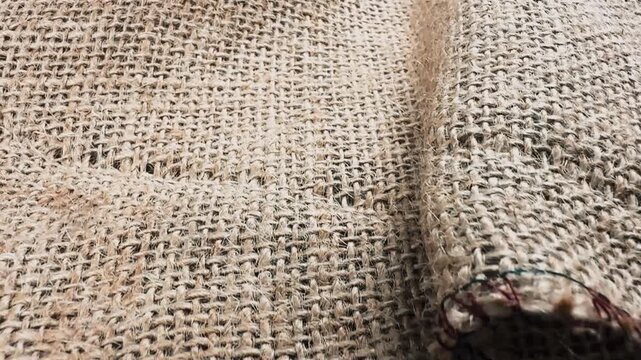 Close up of natural burlap jute fabric texture with stitched edge