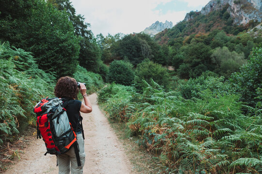 Female hiker with binoculars on Somiedo mountain trail