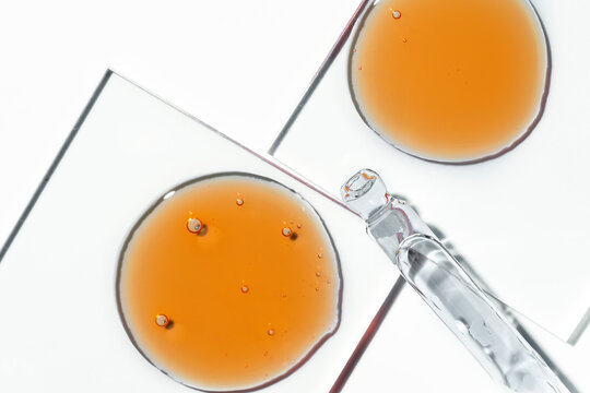Vitamin C serum oil drops with cosmetic bubbles closeup