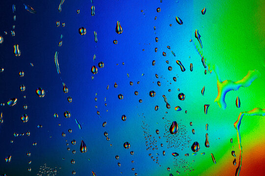 Vibrant neon water drops on colorful surface