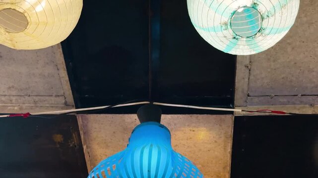Two round paper lanterns hanging from ceiling low angle view night atmosphere