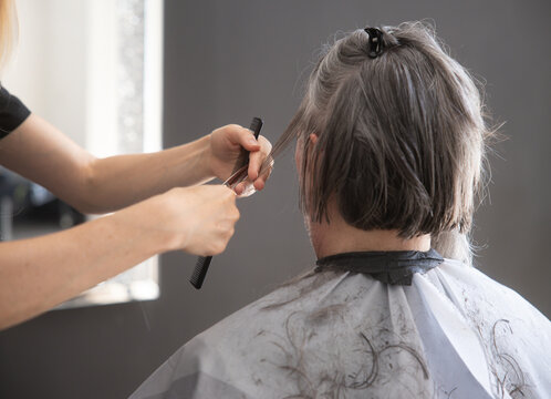 Hairdresser cut short gray hair in a salon