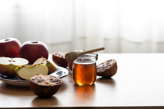 Rosh Hashanah table with apple, honey, and pomegranate
