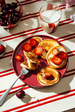 Summer pancake breakfast with strawberry and milk on table
