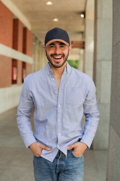 Smiling man in cap and casual shirt in urban walkway