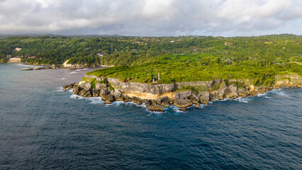 Aerial view of Cabo Frances Viejo, featuring lush green cliffs, dense vegetation, and turquoise waters meeting the Atlantic Ocean in Cabrera, Maria Trinidad Sanchez, Dominican Republic. © robert