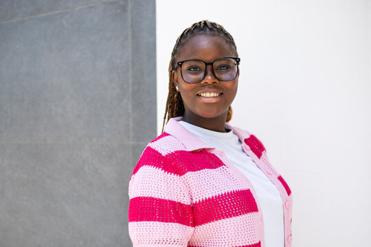 Smiling Black woman with braids wearing glasses outdoors