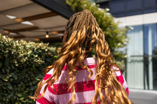 Black woman with long braids walking outdoors in city