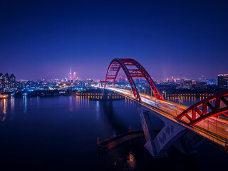 Fototapeta premium Aerial night view of Guangzhou, illuminated cityscape and red bridge over pearl river Guangdong China