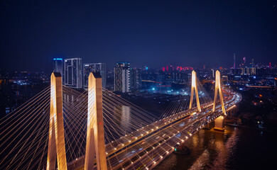 Fototapeta premium Aerial top night view of Guangzhou, illuminated urban landscape and modern bridge in Guangdong China