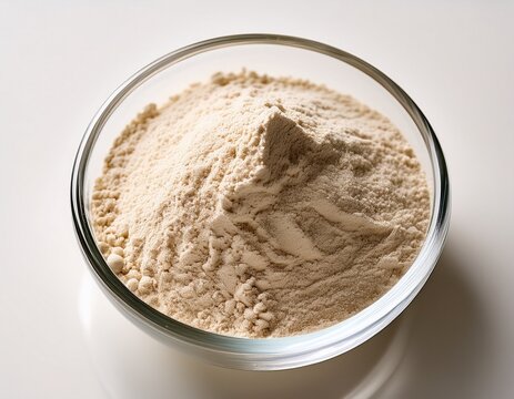 minimalist close up of light beige powder ingredient in a clear glass bowl on a clean white surface with diffused background light