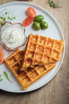 Crunchy waffle fries with sour cream dip served in a basket