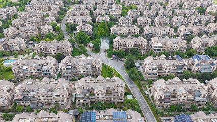 Obraz premium Aerial wide view of dense villa residential community beside lake with lush green trees