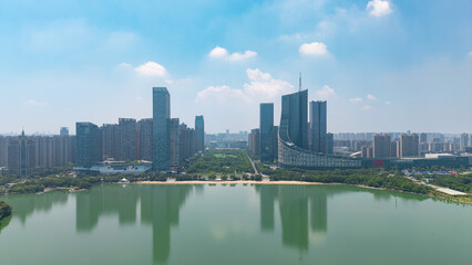 Obraz premium Panoramic cityscape of modern waterfront business district with lake reflecting skyscrapers