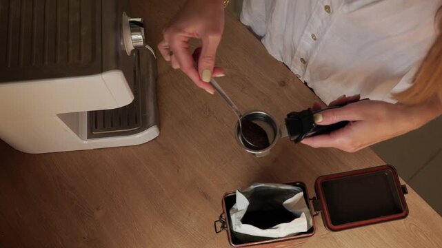 Preparing coffee at home with a coffee maker and a measuring spoon in the kitchen