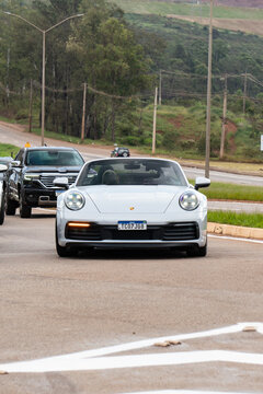 Silver Porsche 911 Cabriolet front view, Luxury convertible sports car driving on street