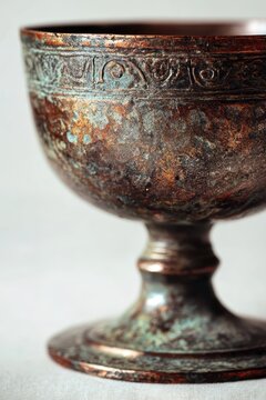 Copper chalice with aged patina, minimal still life on a clean white backdrop