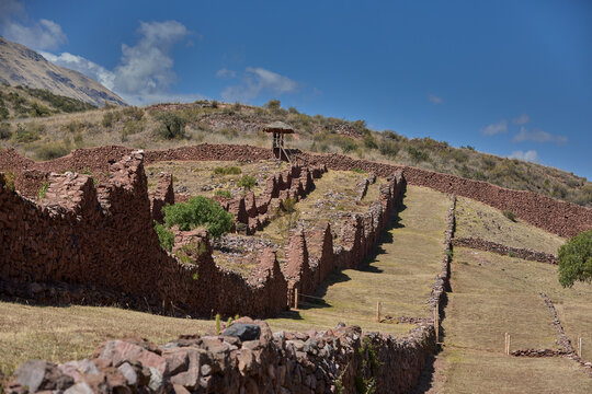 Pikillacta, one of the largest Wari administrative centers ever built outside the Peruvian coast. Rows of small trapezoidal windows and a single stone doorway pierce the massive rammed fieldstone faca