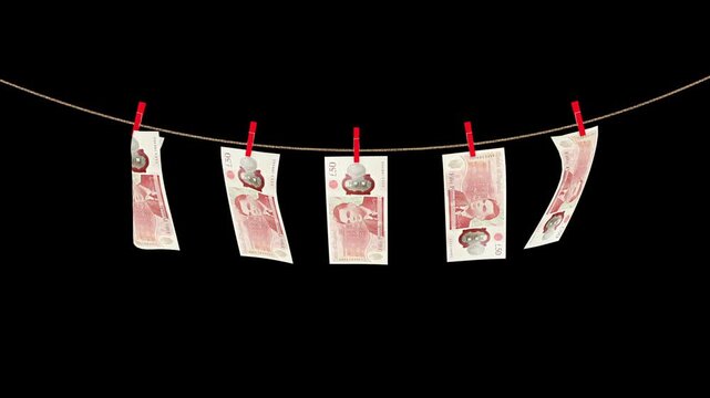 50 british pound banknotes hanging on a rope swaying in the wind