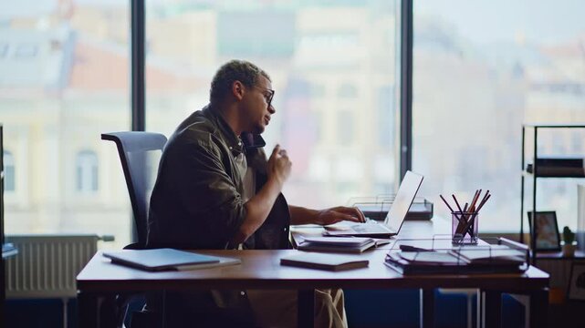 Man on phone call office desk. Frustrated freelancer discussing work problem