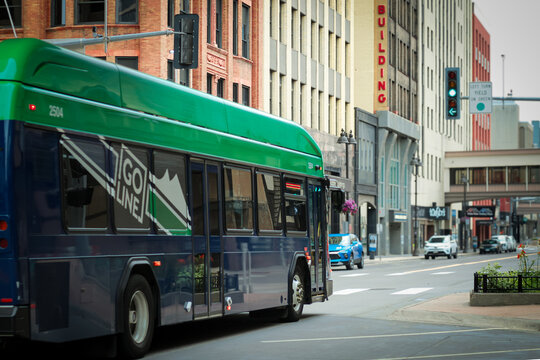 Duluth, MN, USA - Jul 25, 2026: Modern public transit bus drives down Superior Street past historic brick retail office buildings in downtown