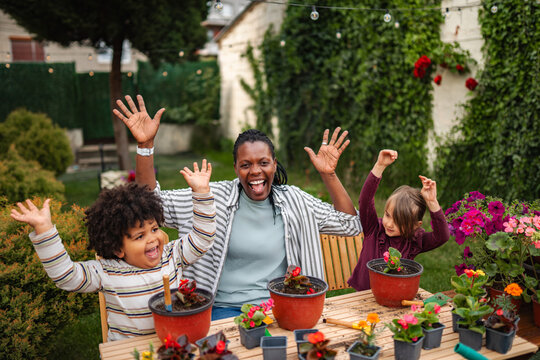 Happy diverse family gardening together in backyard
