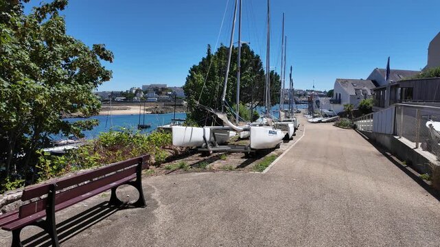 DOUARNENEZ, FRANCE &ndash; July 4, 2026: View along a marina walkway with sailboats stored on land beside calm harbor water in Douarnenez, Brittany, France. Sunny summer day in a coastal sailing area.