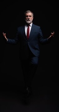 Studio portrait of senior businessman in suit on dark background