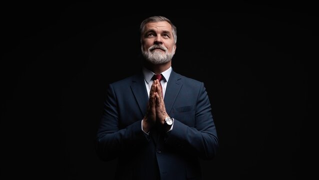 Studio portrait of senior businessman in suit on dark background