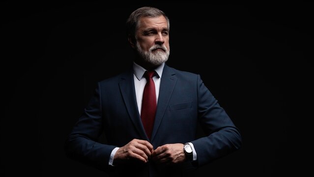 Studio portrait of senior businessman in suit on dark background