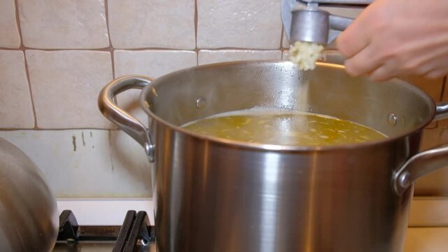 The process of cooking jelly in the apartment of the house you can see the product boiled meat of a person's hands a woman stirring food