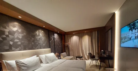 Fotobehang Hotel chique Modern luxury hotel room with twin beds, elegant contemporary interior, warm ambient lighting, workspace and comfortable accommodation.  © Nath Nature