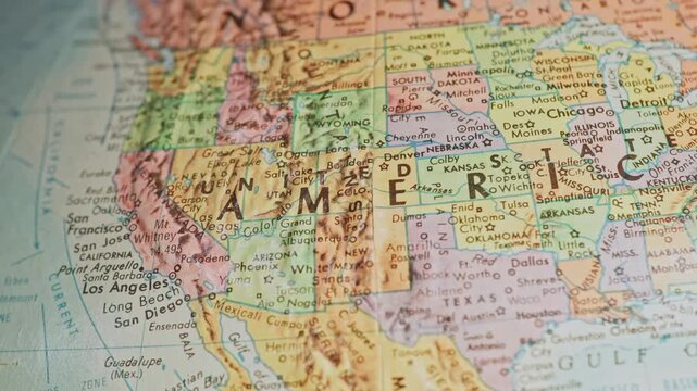 Slow motion macro close up view panning across United States of America map on spherical global chart of globe viewing individual states, cities, rivers, oceans, and locations on North American Earth