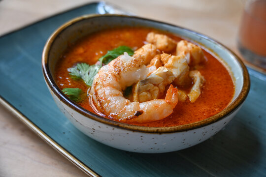 Shrimp and fish stew in tomato sauce, garnished with parsley, served in a bowl, delicious seafood, selected focus