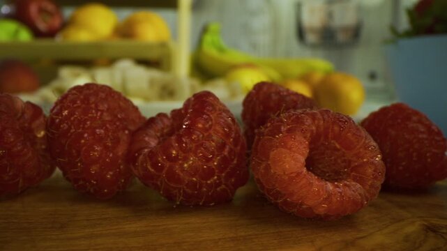 Bunch of beautiful, juicy raspberries in kitchen - closeup, tracking shot
