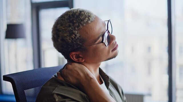 Tired office worker stretching sore neck close up. Man rubbing neck tension