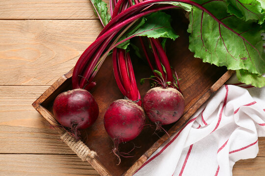 Tray with fresh beetroots on wooden background