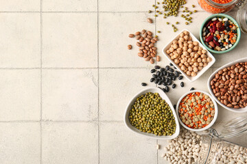 Naklejka na ściany i meble Composition with different raw legumes on light tile background