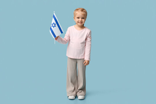 Cute happy little girl with Israel flag on blue background. Hanukkah celebration