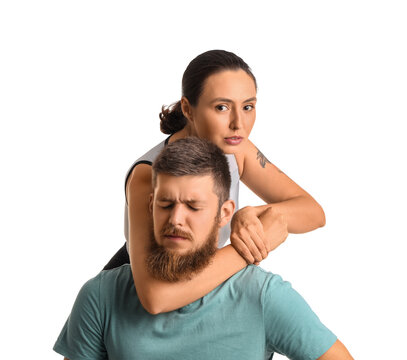 Young woman fighting with instructor of self-defence course on white background
